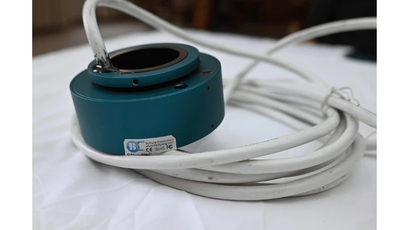Real ByTune through-hole slip ring with blue housing, central bore and white cable leads Real ByTune through-hole slip ring with blue housing, central bore and white cable leads